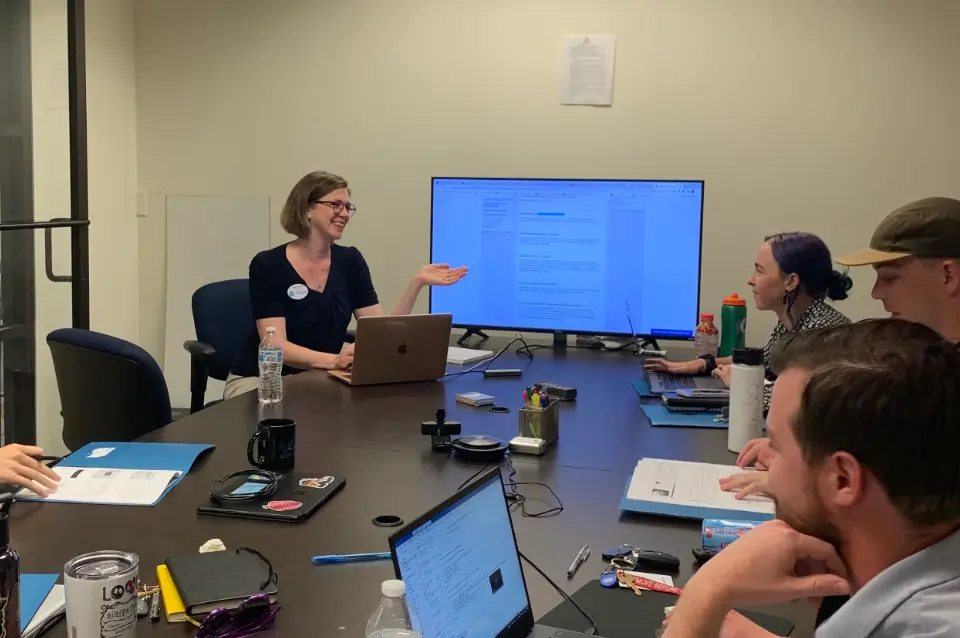 Sarah leads a training in a conference room